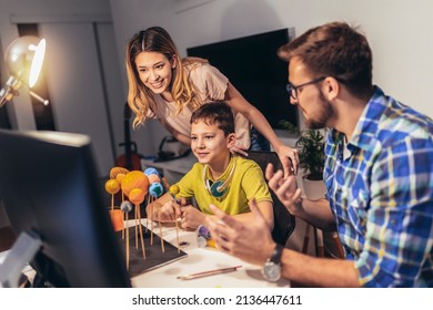 Happy School Boy And His Parent Making A Solar System For A School Science Project At Home