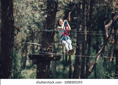 Happy School Girl Enjoying Activity In A Climbing Adventure Park On A Sunny Day