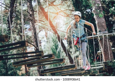 Happy School Girl Enjoying Activity In A Climbing Adventure Park On A Sunny Day