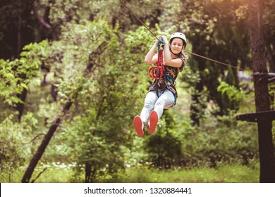 Happy School Girl Enjoying Activity In A Climbing Adventure Park On A Summer Day