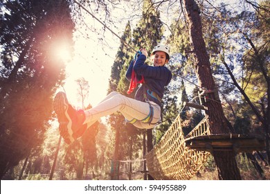 Happy School Girl Enjoying Activity In A Climbing Adventure Park On A Summer Day