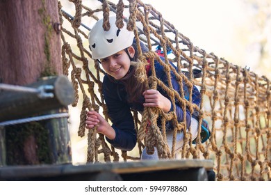 Happy School Girl Enjoying Activity In A Climbing Adventure Park On A Summer Day