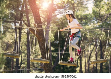 Happy School Girl Enjoying Activity In A Climbing Adventure Park On A Summer Day