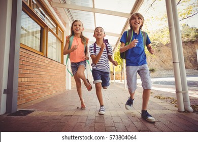 Happy School Kids Running In Corridor At School