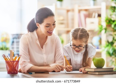 Happy School Time. Mother And Daughter Are Learning To Write. Adult Woman Teaches Child The Alphabet.