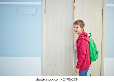 Happy Schoolboy With Backpack Opening Classroom Door