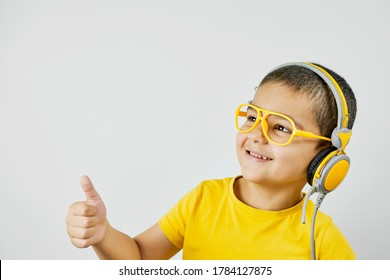 Happy Schoolboy In Yellow. Mixed-race Kid Shows Thumbs-up. Back To School After Covid-19. School Year Start After Long Delay Due To Coronavirus