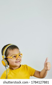 Happy Schoolboy In Yellow. Mixed-race Kid Shows Thumbs-up. Back To School After Covid-19. School Year Start After Long Delay Due To Coronavirus