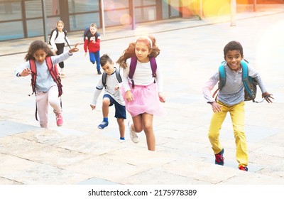 Happy Schoolchildren Running In The Race From School Outdoors At Sunny Day