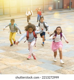 Happy Schoolchildren Running In The Race From School Outdoors At Sunny Day