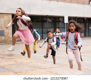 Happy Schoolchildren Running In The Race From School Outdoors At Sunny Day