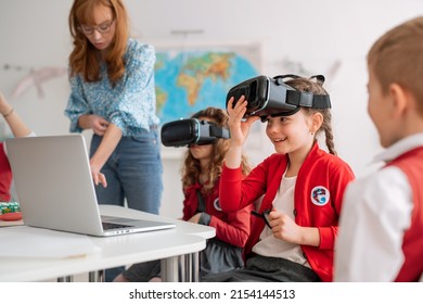 Happy schoolchildren wearing virtual reality goggles at school in computer science class - Powered by Shutterstock