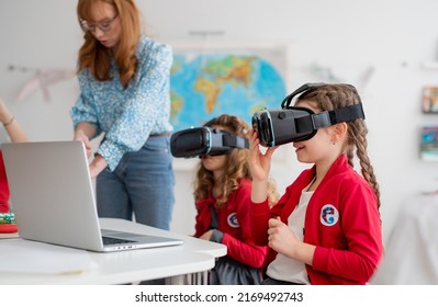 Happy Schoolchildren Wearing Virtual Reality Goggles At School In Computer Science Class