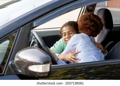 Happy Schoolgirl Embracing Her Mom Before Going To School While Both Sitting In The Car