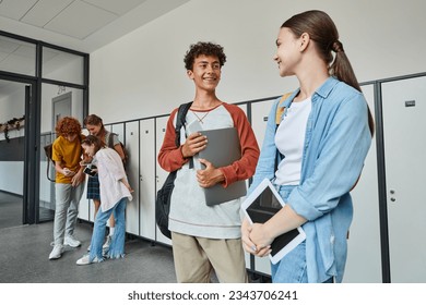 happy schoolkids holding devices in hallway, back to school concept, smile, students and technology - Powered by Shutterstock