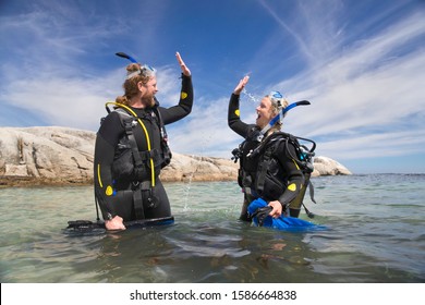 Happy Scuba Diver Couple In Ocean Celebrating Dive With A High Five