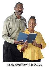 A Happy Senior African American Couple Sing A Duet From The Same Book.  On A White Background.