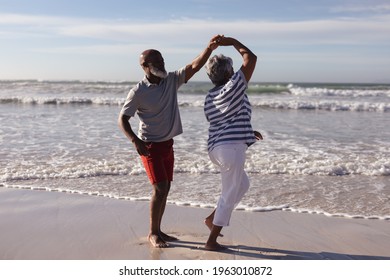 Feliz pareja de adultos afroamericanos bailando juntos en la playa. concepto de estilo de vida de jubilación de vacaciones de viajes