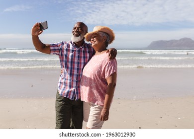 Happy senior african american couple taking a selfie from smartphone on the beach. travel vacation retirement lifestyle concept - Powered by Shutterstock