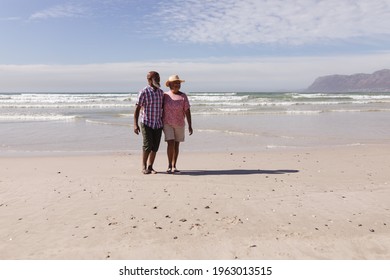 Happy Senior African American Couple Walking Together On The Beach. Travel Vacation Retirement Lifestyle Concept