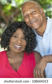 A happy senior African American man and woman couple in their sixties outside together smiling.