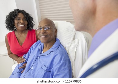 Happy senior African American man patient recovering in hospital bed with male doctor and wife