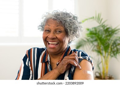 Happy senior african american woman with plaster on arm looking at camera after vaccination. senior health and lifestyle during covid 19 pandemic. - Powered by Shutterstock