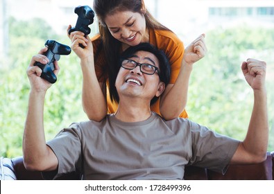 Happy Senior Asain Couple Are Playing A Game Together