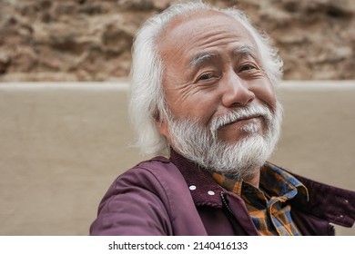 Happy senior asian man smiling on camera - Elderly person taking a selfie - Powered by Shutterstock