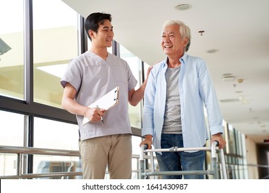 Happy Senior Asian Woman Talking To Physical Therapist In Rehab Center