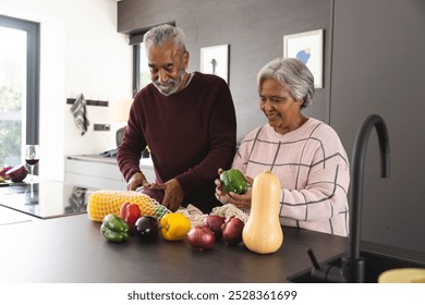 Happy senior biracial couple unpacking bags of vegetables in kitchen at home. Senior lifestyle, retirement, food, shopping and domestic life, unaltered. - Powered by Shutterstock