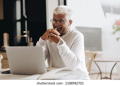 Happy senior businessman attending an online meeting in his home office. Mature businessman having a video conference with his colleagues while working from home. - Shutterstock ID 2188982701