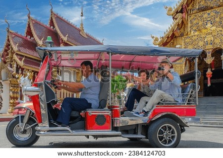 Happy senior Caucasian tourist enjoy tuktuk taxi ride on sightseeing temple tour in Thailand. Tuktuk ride in Thailand. Exciting transport.