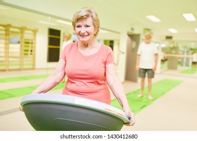 Happy Senior Citizen With Bosu Ball In A Fitness Class In Rehab In Physiotherapy