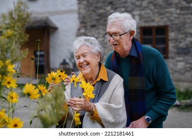 Happy Senior Couple At Autumn City Walk, Posing With Flowers.