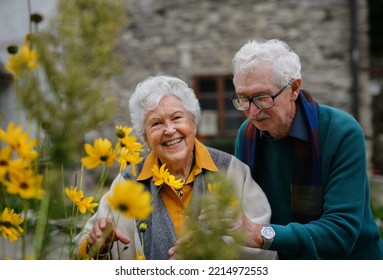 Happy Senior Couple At Autumn City Walk, Posing With Flowers.