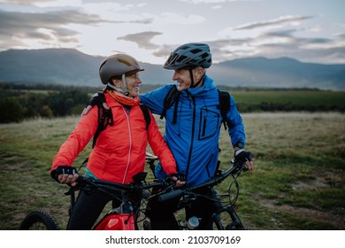 Happy senior couple bikers wmbracing outdoors in nature in autumn day. - Powered by Shutterstock