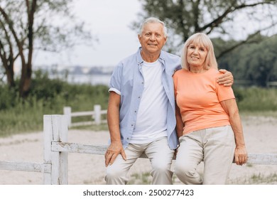 Happy senior couple bonding and spending quality time together outdoors in a serene park setting. - Powered by Shutterstock