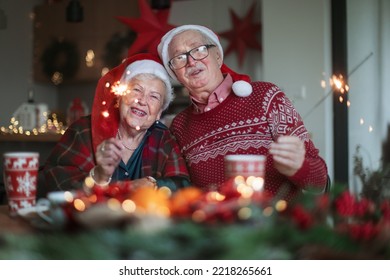 Happy senior couple celebrating Christmas Eve with sparklers. - Powered by Shutterstock