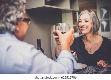 Happy senior couple cheering with red wine - Powered by Shutterstock