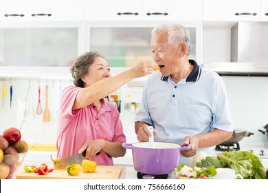happy senior couple cooking in kitchen