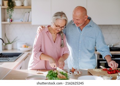 Happy Senior Couple Cooking Together At Home.