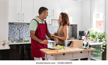 Happy senior couple cooking together in a modern kitchen, surrounded by fresh ingredients, enjoying quality time and togetherness - Powered by Shutterstock