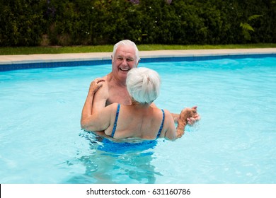 Happy senior couple dancing in the pool - Powered by Shutterstock