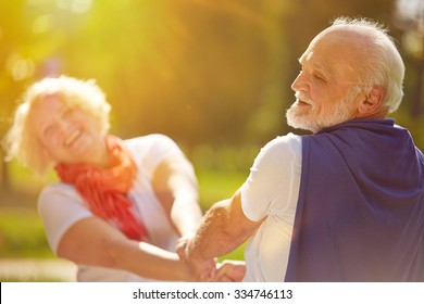 Happy senior couple dancing in the sun in summer in nature