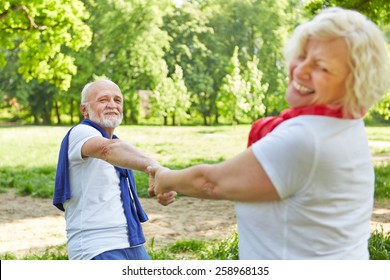 Happy senior couple dancing together in nature in summer