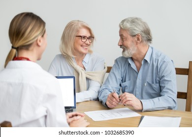 Happy Senior Couple Deciding Discussing New House Purchase At Meeting With Agent, Smiling Older Aged Family Consulting About Buying Home, Taking Mortgage Loan, Making Investment Or Real Estate Deal