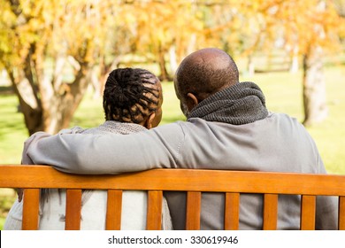 Happy senior couple discussing together on a bench in parkland