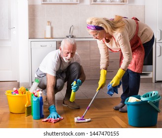 Happy Senior Couple Doing Chores Together On Floor