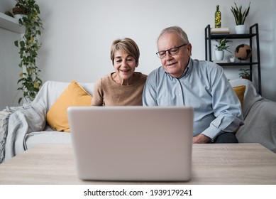 Happy Senior Couple Doing Video Call At Home - Main Focus On Woman Face